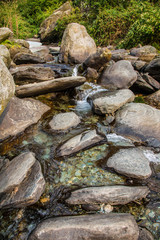 water flows over stones. Beautiful mountain waterfall in the forest. 
