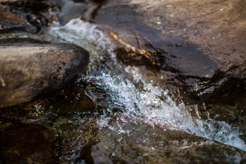 water flows over stones. Beautiful mountain waterfall in the forest. 