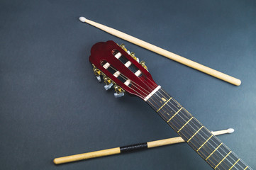 Drumsticks and guitar headstock close up. acoustic musical instrument