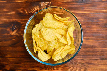 Glass plate with chips on a burnt wooden background. Top view.