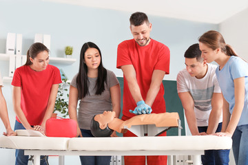 Instructor demonstrating CPR on mannequin at first aid training course