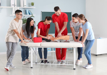 Instructor demonstrating CPR on mannequin at first aid training course