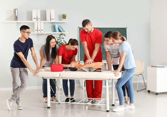 Instructor demonstrating CPR on mannequin at first aid training course