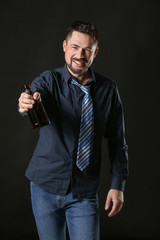 Fototapeta premium Mature man drinking alcohol on dark background
