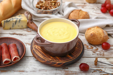 Cheese fondue with snacks on table