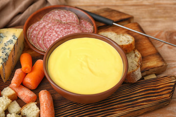 Cheese fondue with snacks on table