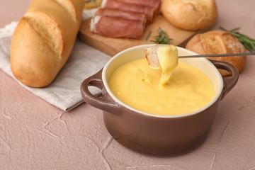 Dipping of crouton into cheese fondue on table