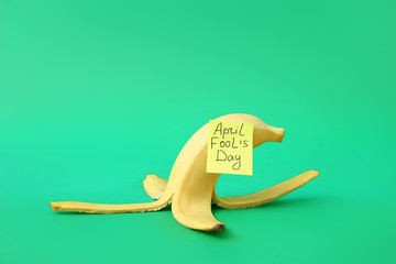 Banana peel on color background. April Fool's Day prank