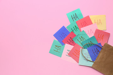 Bag with papers on color background. April Fool's Day prank