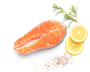 Raw salmon steak and spices on white background