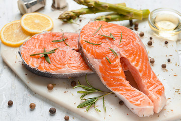 Raw salmon steaks and spices on table