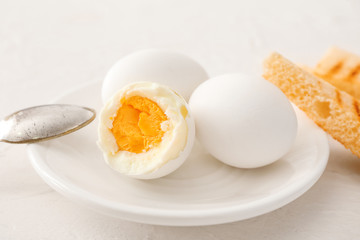 Plate with tasty boiled eggs on table