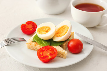Healthy breakfast with boiled eggs, toasted bread and tomatoes on table