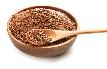 Bowl and spoon with flax seeds on white background