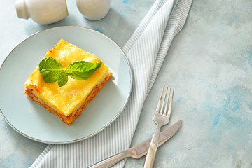 Plate with piece of tasty homemade lasagna on table