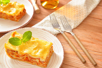 Plate with piece of tasty homemade lasagna on table