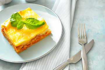 Plate with piece of tasty homemade lasagna on table