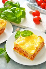 Plate with piece of tasty homemade lasagna on table