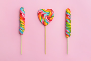 Tasty lollipops on color background