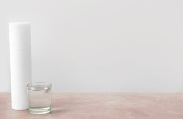 Glass of clean water and filter on table