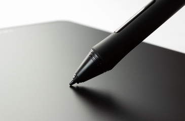 Pen on graphic tablet. Side view on white background.