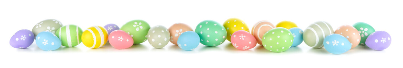 Easter eggs scattered forming a long border isolated on a white background. Pastel colors.