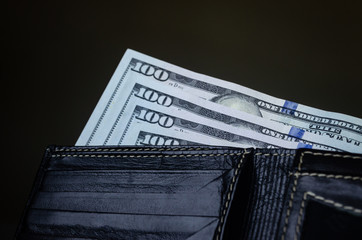 Billetes de cien dólares americanos introducidos en cartera o billetera negra 