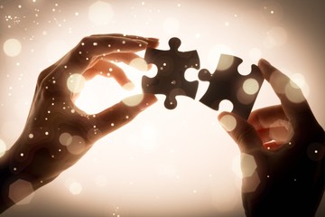 Human hands holding puzzle pieces