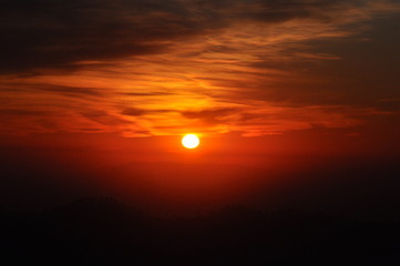 Dark orange sunset sky background with clouds all around