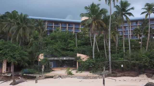 Aerial shot of drone surveying devastation of an abandoned beach hotel resort after hurricane Maria