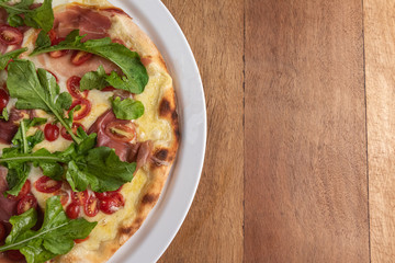 Pizza on the brown wooden table