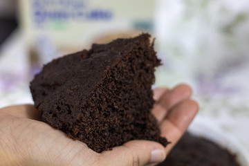 hands holding chocolate cake