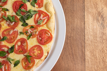 Pizza on the brown wooden table