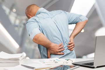 Business man with back pain in office