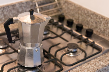 Moka pot, traditional Italian coffee maker put on the stove.