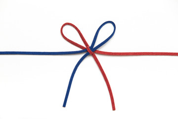 red and blue ribbon isolated on white background. two colors chamois string tied in a bow. 