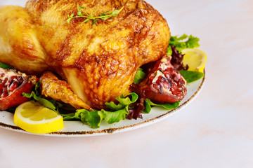 Roasted turkey on plate with herbs and pomegranate.