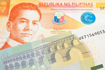 An orange twenty piso note from the Philippines close up in macro with a five Euro note from the European Union eurozone