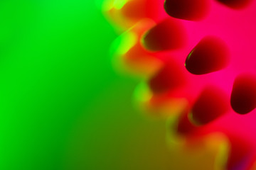 Close-up of a red-pink bacterium floating in a green liquid. Chinese Coronavirus. Blurred green...