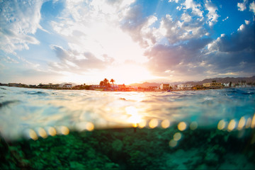 Town of Dahab during sunset hour, splitted view from the water with coral reef visible underwater