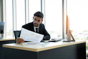 Young businessmen are stressed and holding paperwork sheet for customer or partner. He must send the balance of the business to the partner. Leadership concept. Soft focus.