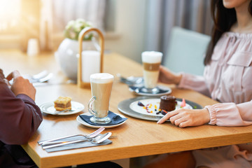 Young Couple Enjoying Coffee And Cake In Cafe