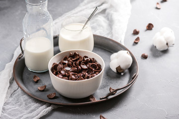 Milk with chocolate corn flakes cereal in bowl