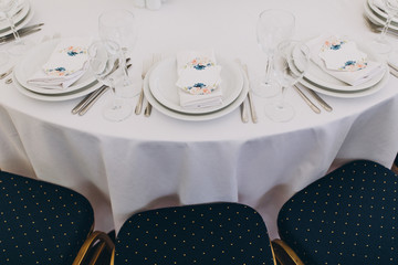 holiday tables are decorated with compositions of flowers and greenery, on the tables are...