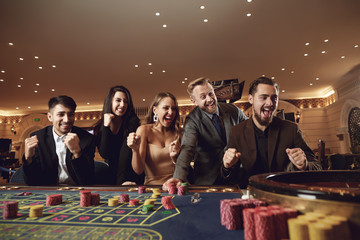 People gamble at night at the roulette table in a casino.