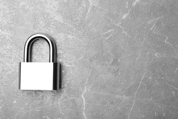 Steel padlock and space for text on marble background, top view. Safety concept