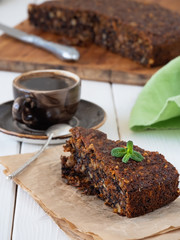 Sweet carrot cake wiht walnut on white table background. Near stand cup with black coffee espresso. Shallow focus, close up