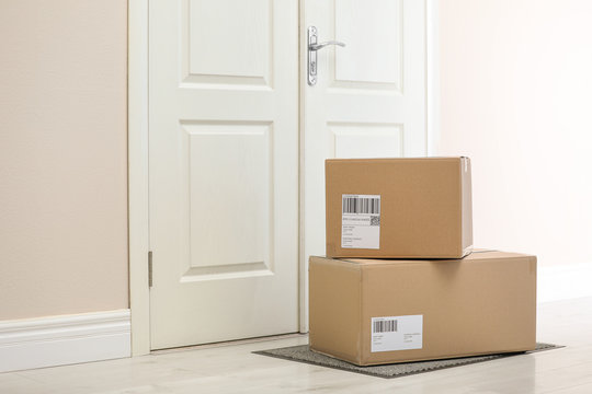 Parcels on rug near door. Delivery service