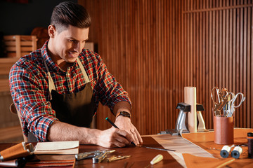 Man working with piece of leather in workshop