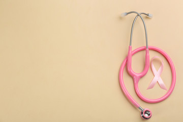 Pink ribbon and stethoscope on beige background, flat lay with space for text. Breast cancer concept